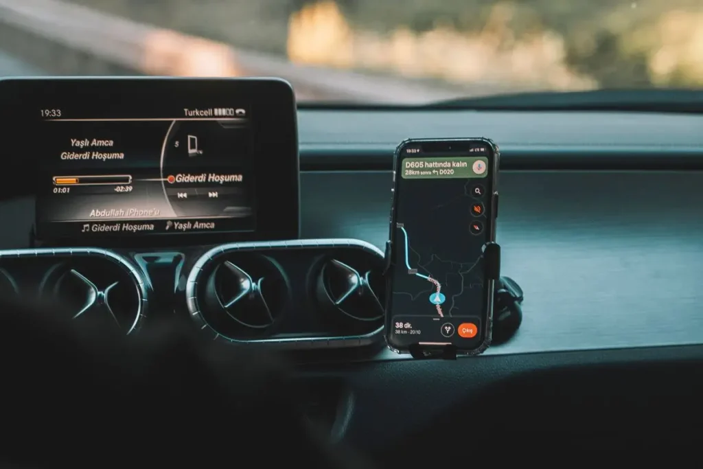 A cat from inside the car (Dashboard) showing the open road ahead with the help of the tracking system (GPS/Maps).